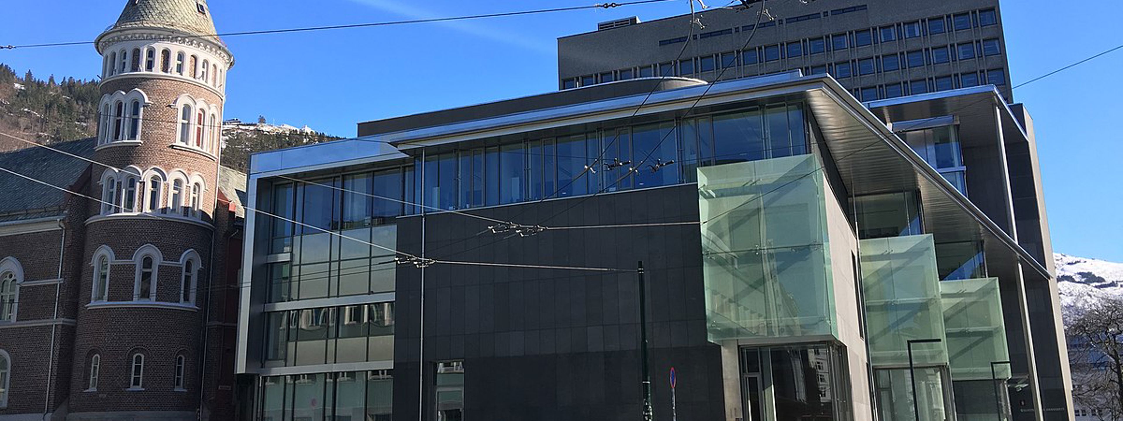 Frontpartiet til Gulating Lagmannsrett i Bergen. Bygget har brune plater og store glassvindu. Til venstre for bygget ligg den gamle brannstasjonen, eit raudt mursteinshus med tårn.